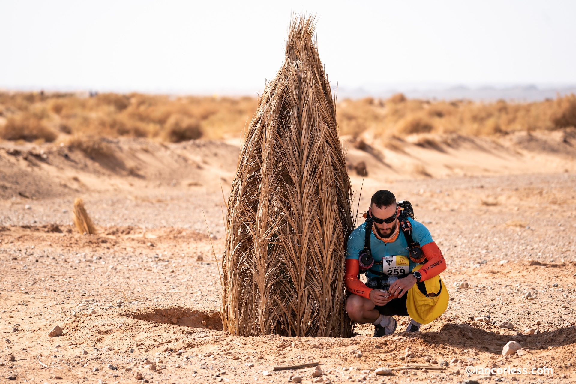 Runner seeking shade in Marathon des Sables